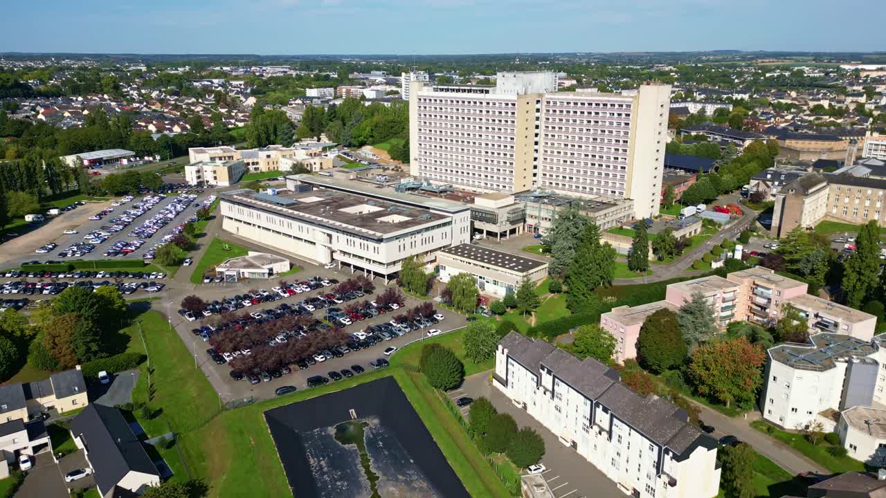 Aerial approach of hospital complex, Centre Hospitalier Laval with surrounding roads and parking