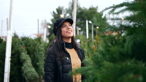 Una-Mujer-Hermosa-Con-Un-Espíritu-Navideño-Feliz-Sonriendo-Mientras-Compra-árboles-De-Navidad-Festivos-De-Abeto-Douglas