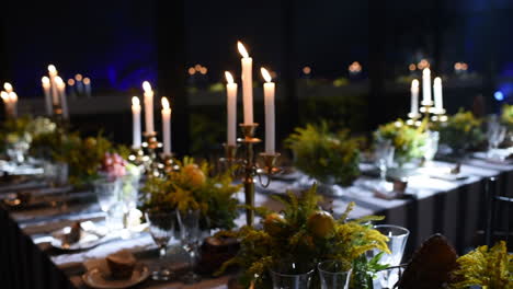 elegant dining table decorated with candles and floral arrangements at night