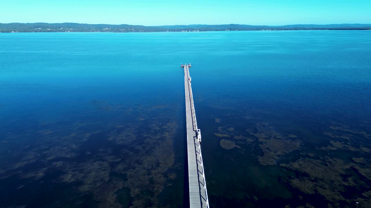 Drone aerial landscape of Long Jetty wooden boardwalk pier wharf waterfront in Tuggerah Lake water catchment The Entrance suburban town Central Coast Australia travel tourism coastline