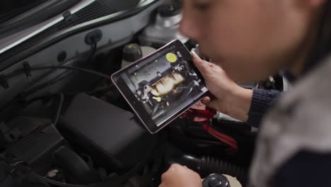 Mecánica-Femenina-Usando-Tableta-Digital-E-Inspeccionando-El-Automóvil-En-Una-Estación-De-Servicio-De-Automóviles