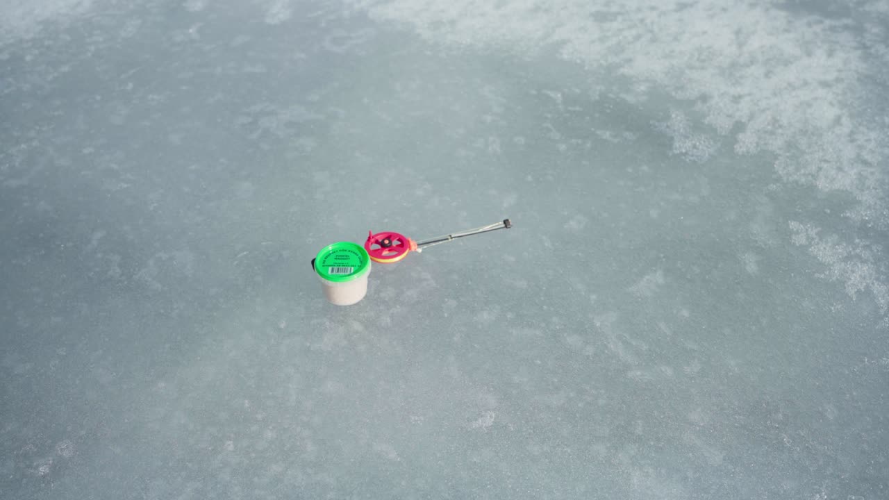 얼어붙은 호수 에 가운 얼음 시 로드 와 미끼 를 넣는 사람