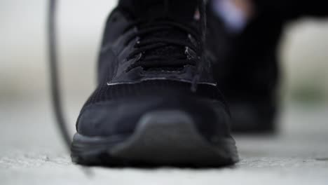 caucasian male ties shoelaces on black running shoes, slomo