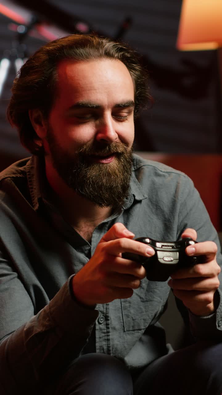 Vertical video Excited man holding controller in apartment, playing videogames