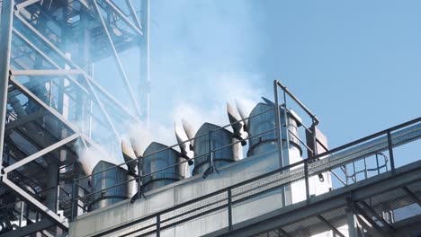 Intense white smoke from the company's chimneys. Metal structures of the plant. Fuel combustion and environmental pollution. Global climate warming