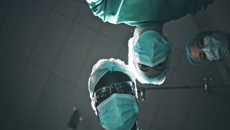 surgical team looking down at patient in operating room