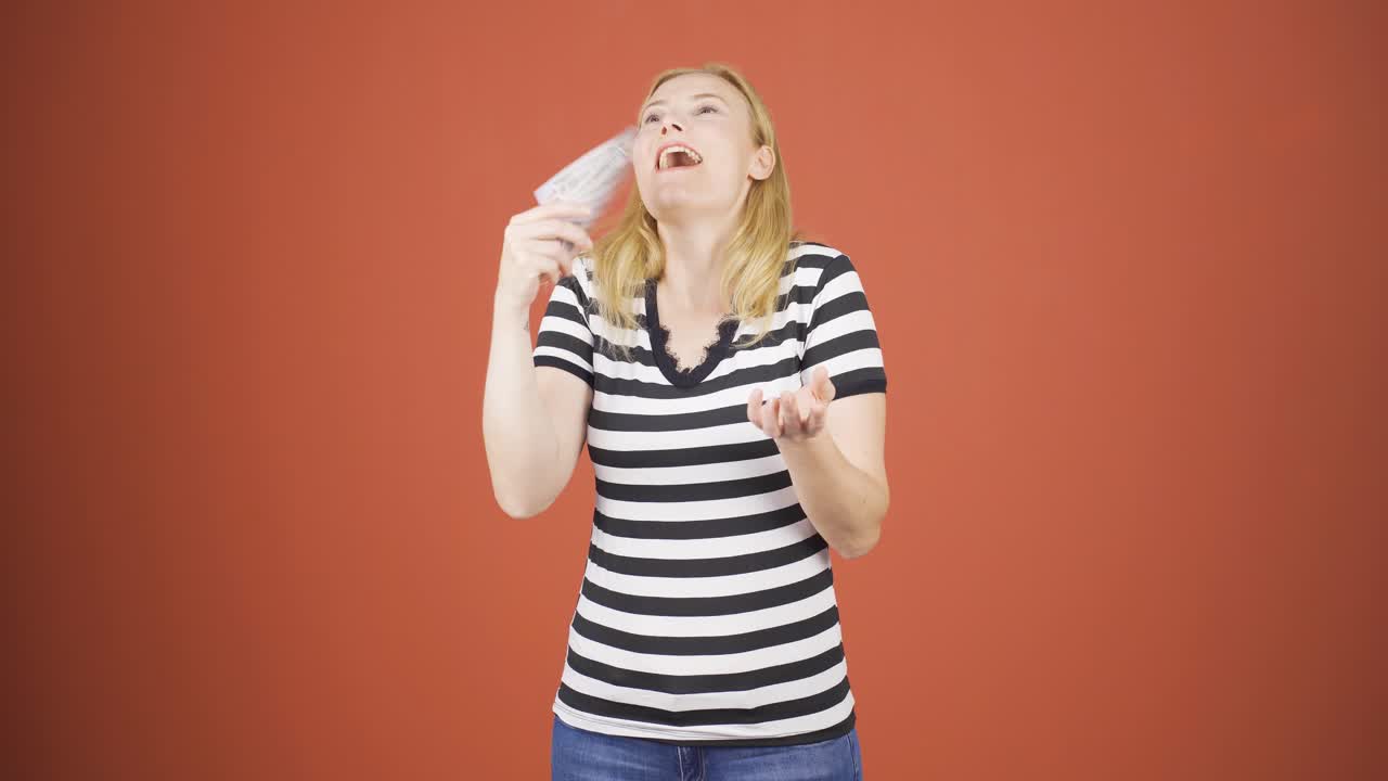 여성이 지폐를 배포하고 공중에 던지고 있습니다.