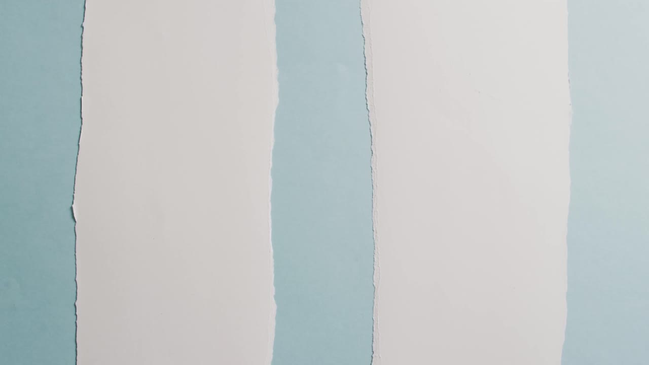 video de primer plano de pedazos rasgados de papel blanco sobre fondo azul