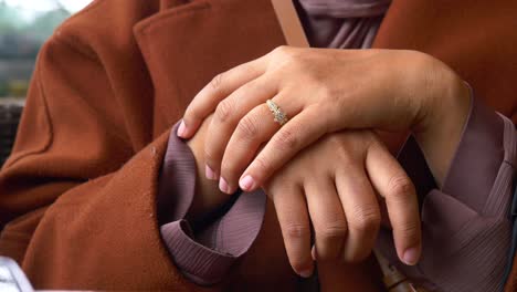 close-up of a woman's hands wearing a gold ring