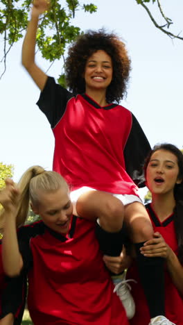 female football team celebrating a win in the park