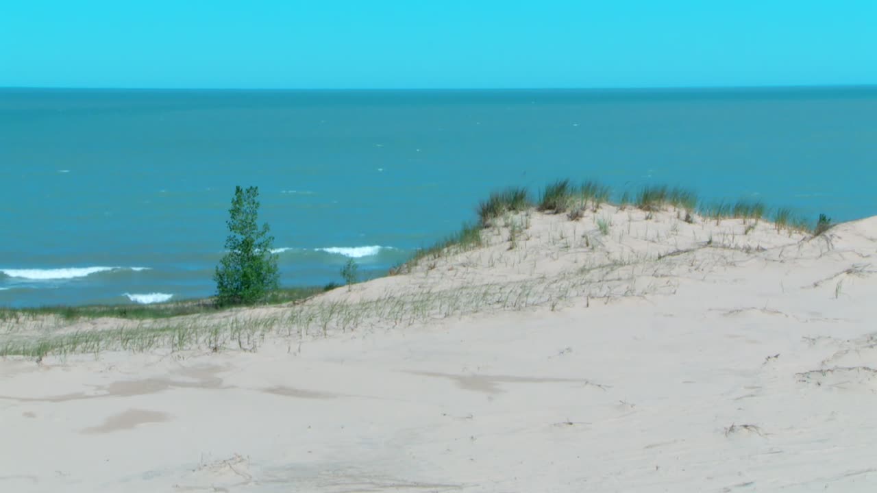 Sand Dunes With Turquoise Blue Sea In The Background. - wide shot