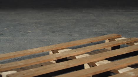 worker dismantling a wooden pallet