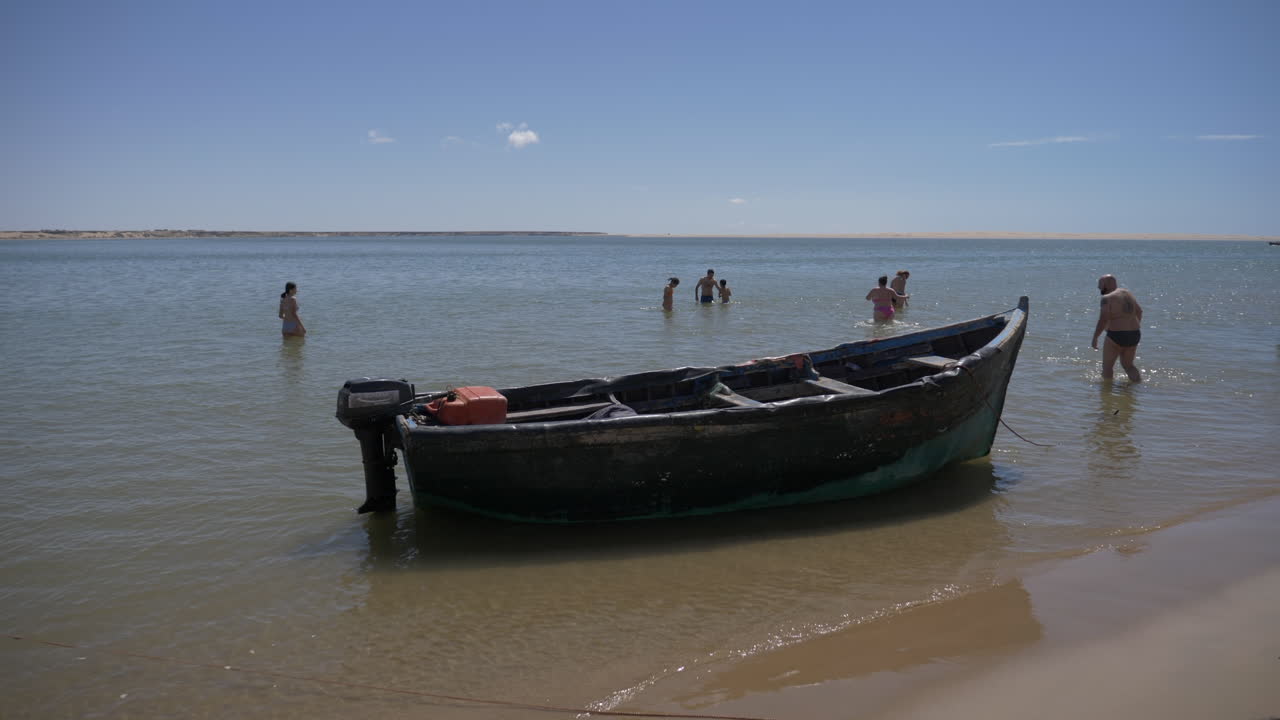 la gente disfruta de la laguna nayla en marruecos detrás del barco pescador