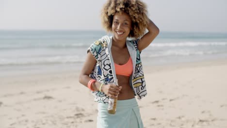 mujer con botella contra la playa de arena
