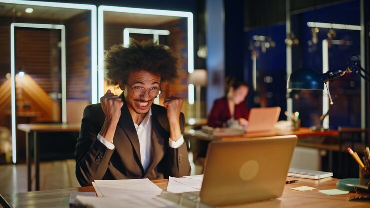 Overjoyed office worker throwing papers air night workplace. Career success win.