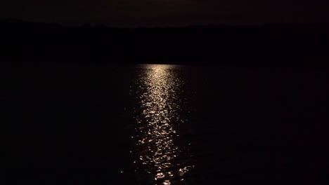 bright moon rays reflection on rippling lake water at night 4k