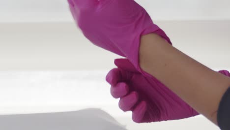 close up of a female doctor putting on latex gloves