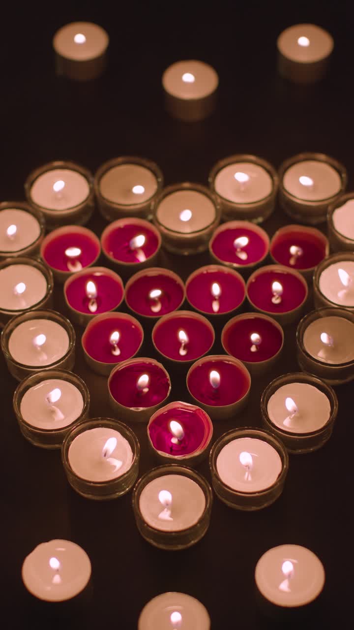 video vertical de velas rojas y blancas románticas en forma de corazón sobre fondo negro 2