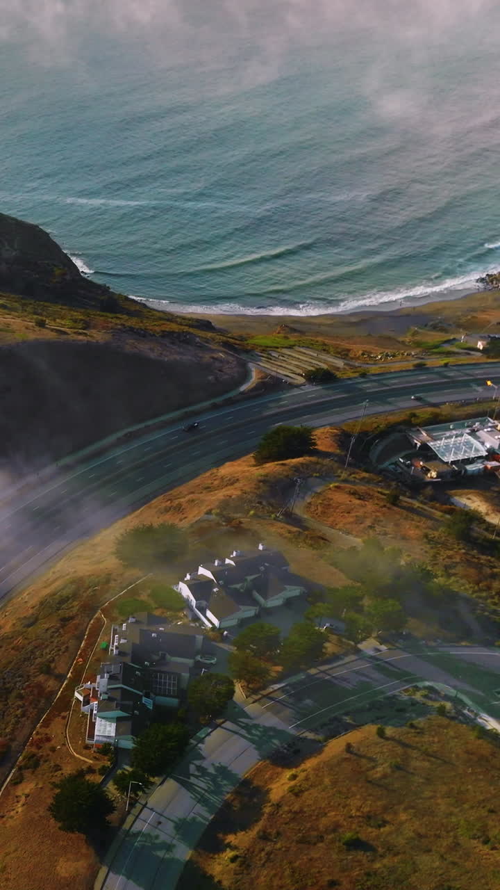 Road passing through the rocks of Montara, California, USA. Drone descending over the hill on the State Beach of Montara. Vertical video