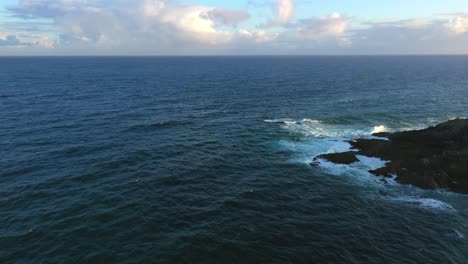 waves crashing against tip of island