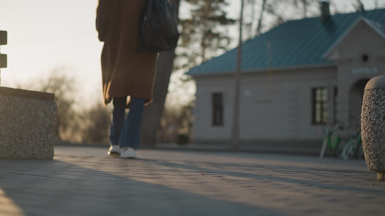 흐릿한 공원에서 고 있는 소녀, 은 그녀의 다리와 발에 초점을 맞추며 시작됩니다. 이미지는 는 움직임과 외로움을 포착합니다. 배경은 부드럽게 초점을 벗어납니다.