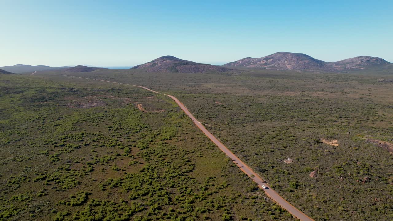 video de drone de 4k de una camioneta blanca conduciendo a través de los paisajes verdes del parque nacional cape range, esperance, australia occidental