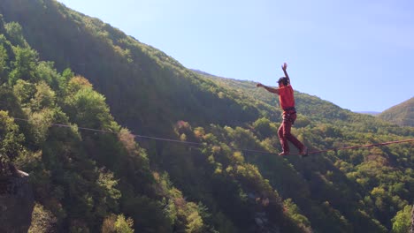 man slacklining on mountain ridge