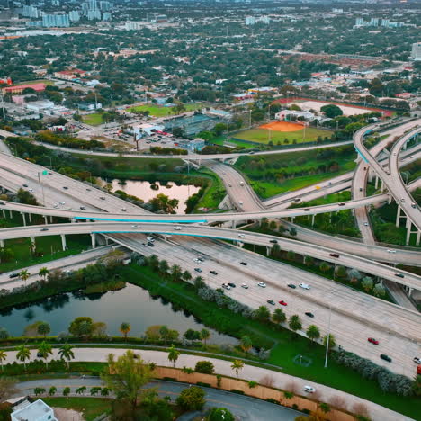road interchange of highways and freeways in colorful miami. city scenery with lively traffic from top view.