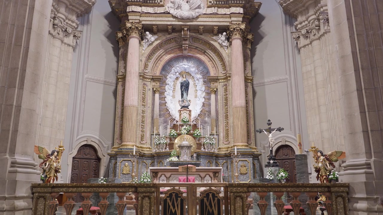 Altare maggiore dorato e statua della Vergine Maria incoronata affiancata da angeli in una chiesa in Portogallo