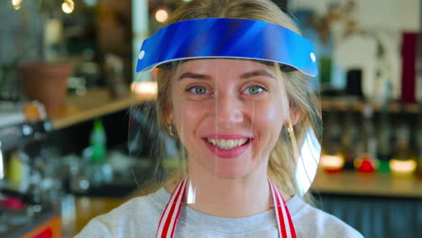 woman wearing a face shield in a coffee shop