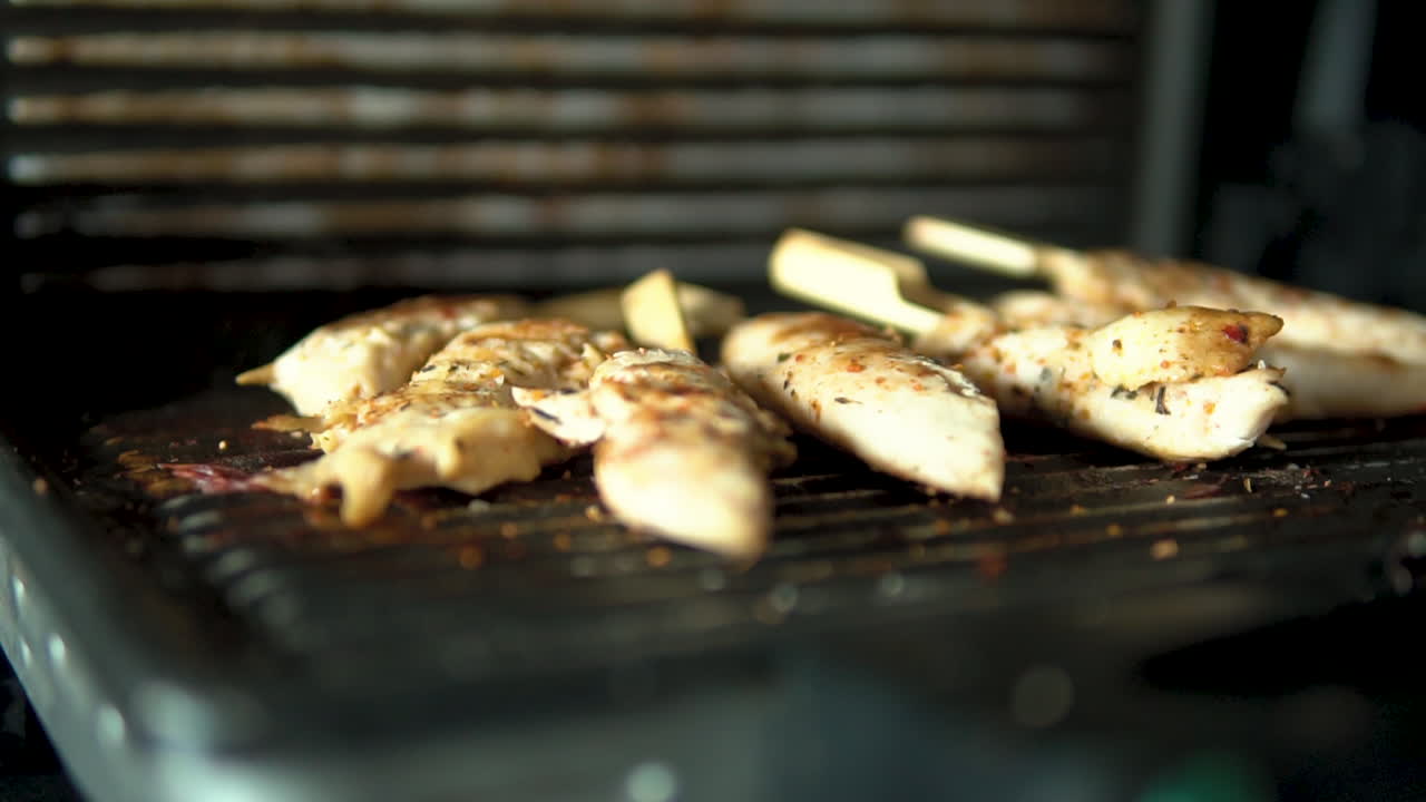 Close-up smoked chicken meat on grill, slow motion