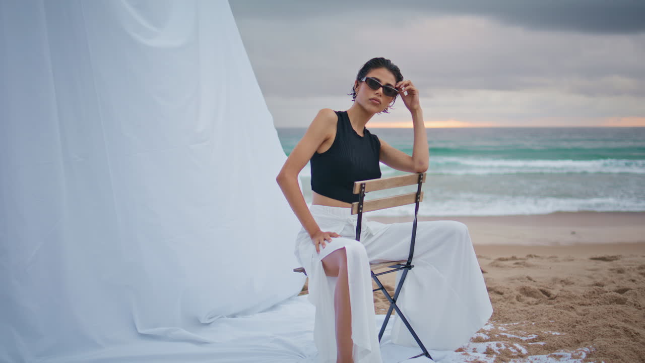 해변에서 선글라스를 입고 포즈를 취하는 매력적인 소녀. 전문 모델 촬영