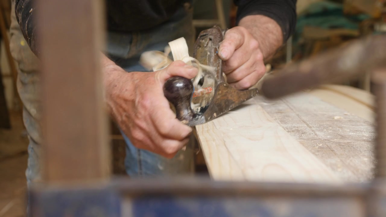 Hand planing plank creating bevel boat building
