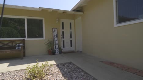 front gate of a house for sale with a hello sing board