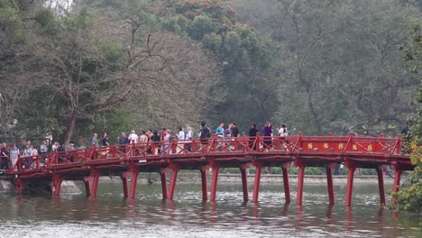 tourists walking across a scenic red bridge