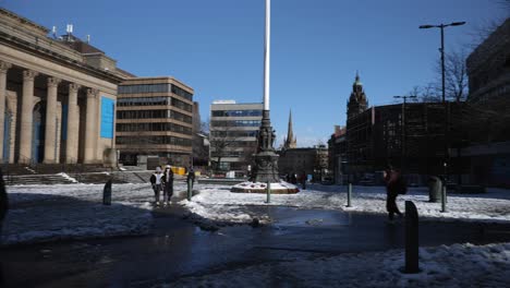 sheffield city hall and square during snow on sunny day, wide, panning shot