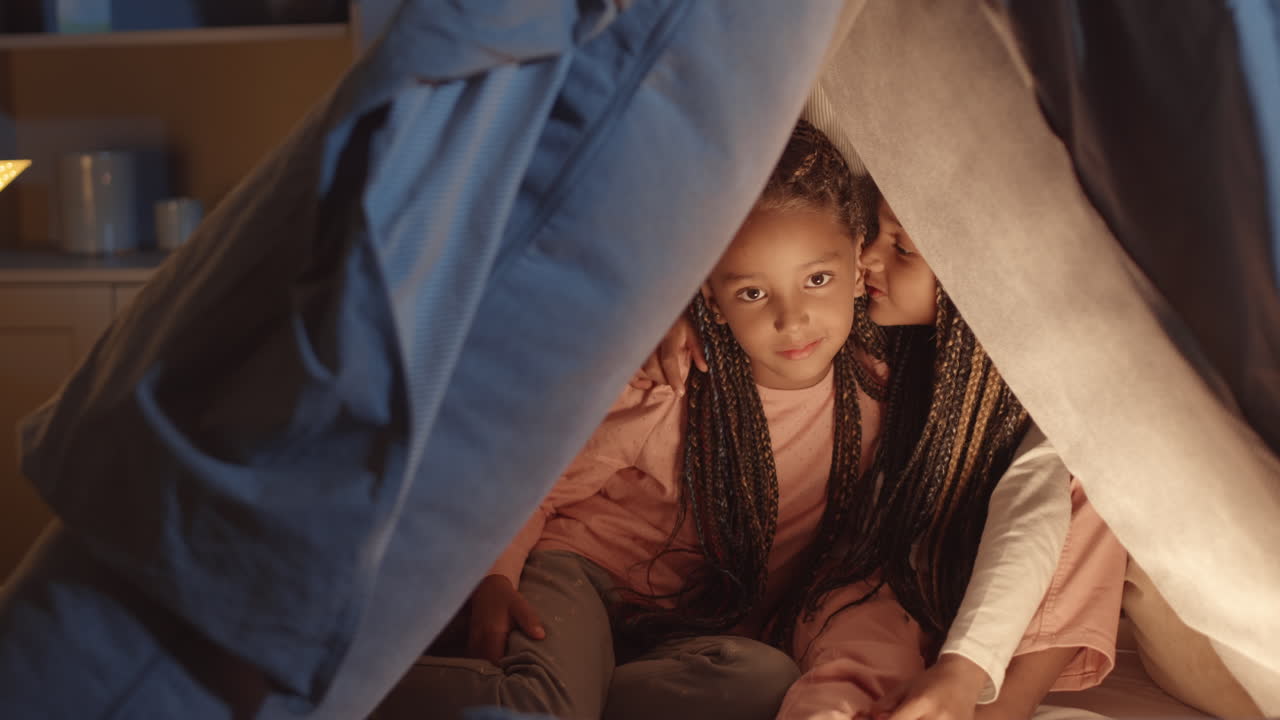 Sisters Sharing Secrets in Pillow Fort
