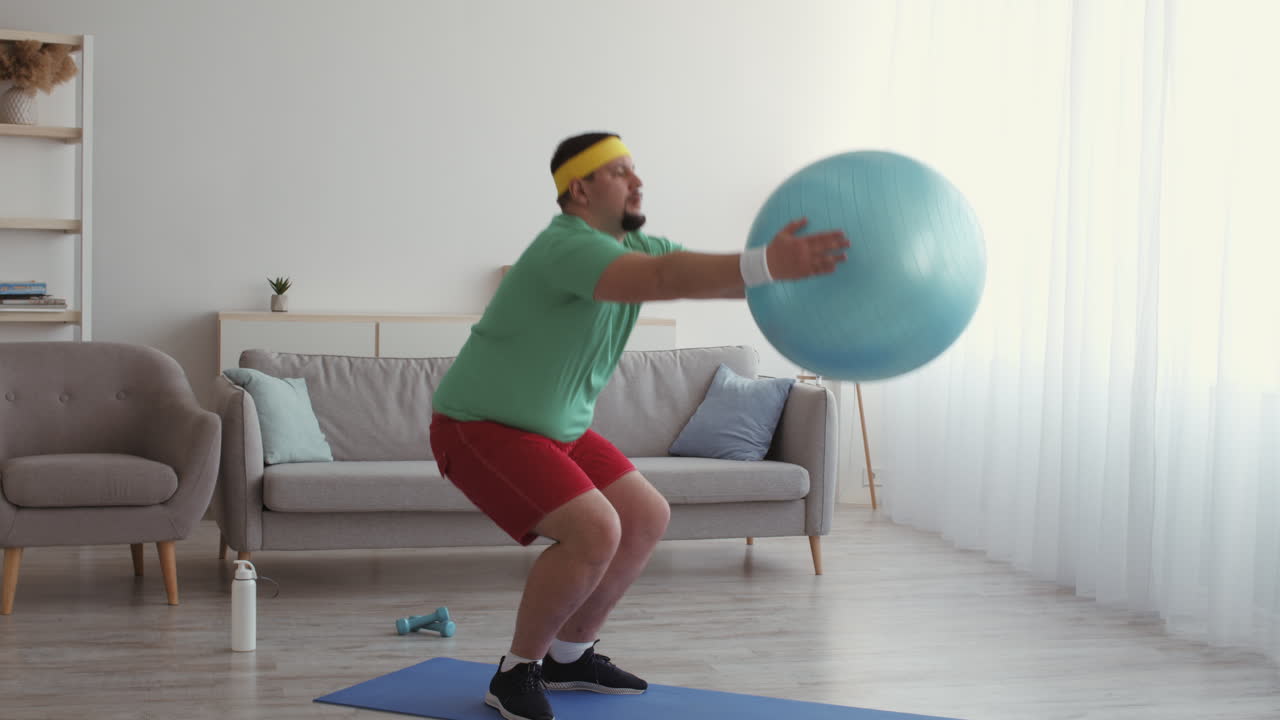 hombre obeso haciendo ejercicio con una pelota de estabilidad en casa
