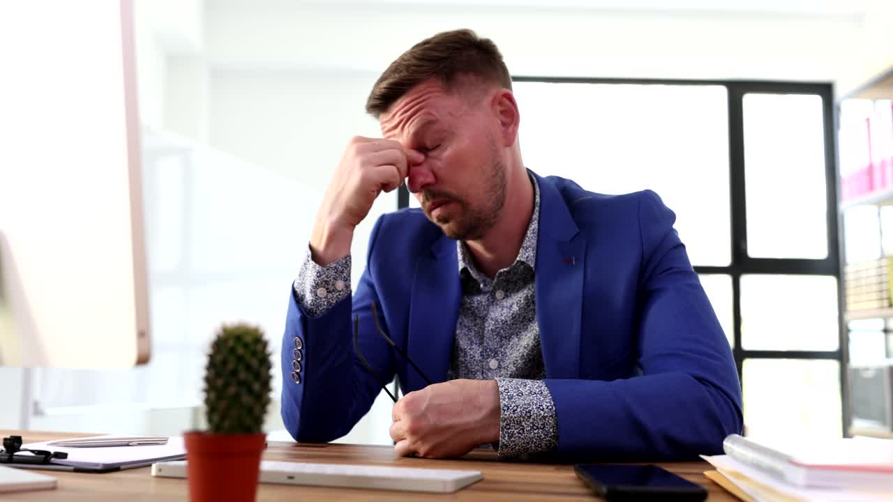 Tired businessman typing on computer and taking off his glasses 4k movie