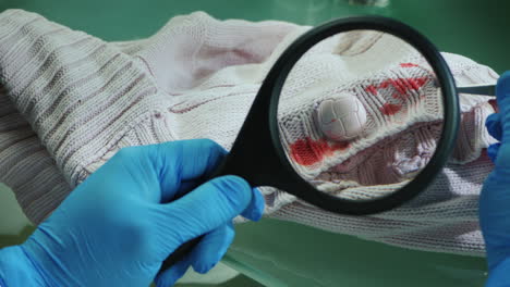 crime lab worker examines evidence on clothes 1