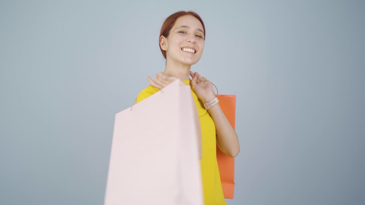 쇼핑 가방을 들고 춤추는 여자.