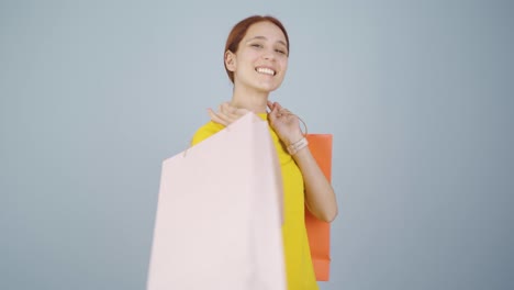 mujer bailando con bolsas de compras.
