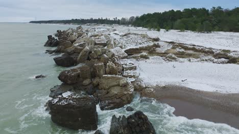 Aerial-establishing-view-of-abandoned-seaside-fortification-buildings-at-Karosta-Northern-Forts-on-the-beach-of-Baltic-sea-,-overcast-winter-day,-wide-drone-shot-moving-forward