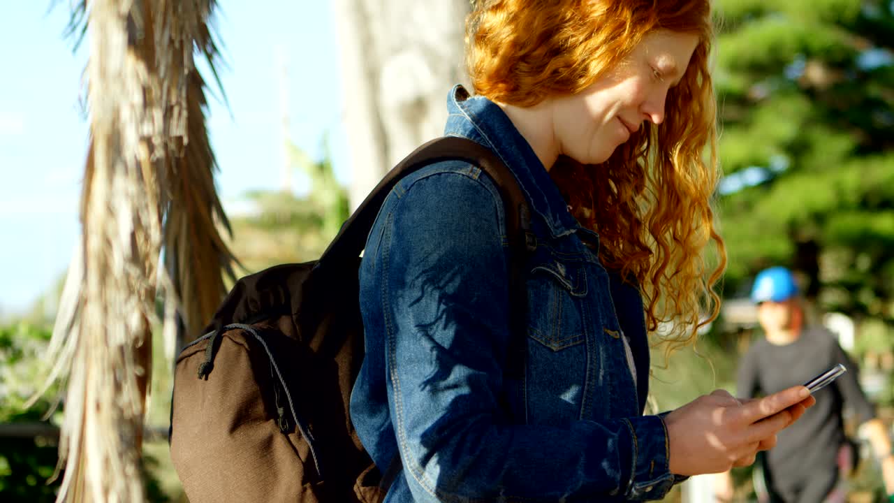 mujer usando teléfono móvil en la playa 4k