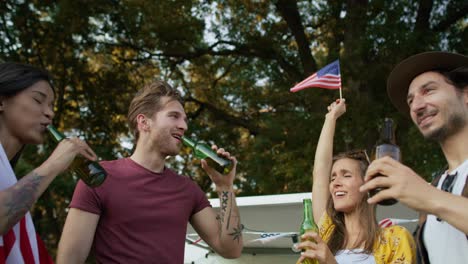group of young friends celebrating 4th of july on the camping.
