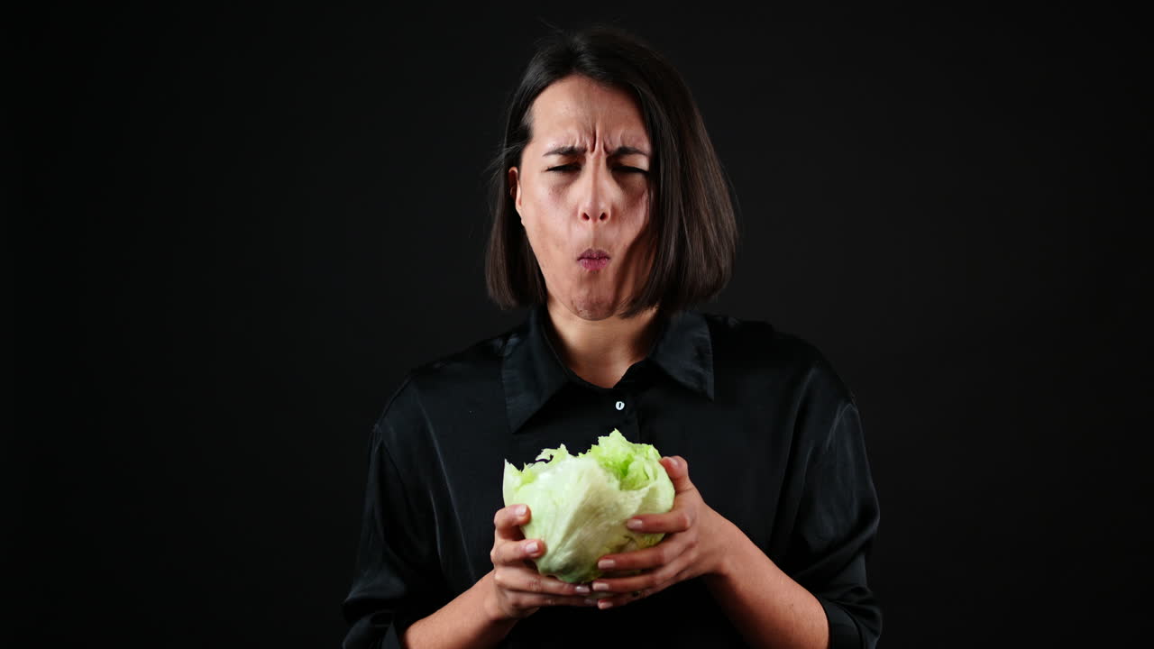 retrato de mujer joven mordiendo repollo y disfrutando del sabor, concepto de comida sana vegana orgánica