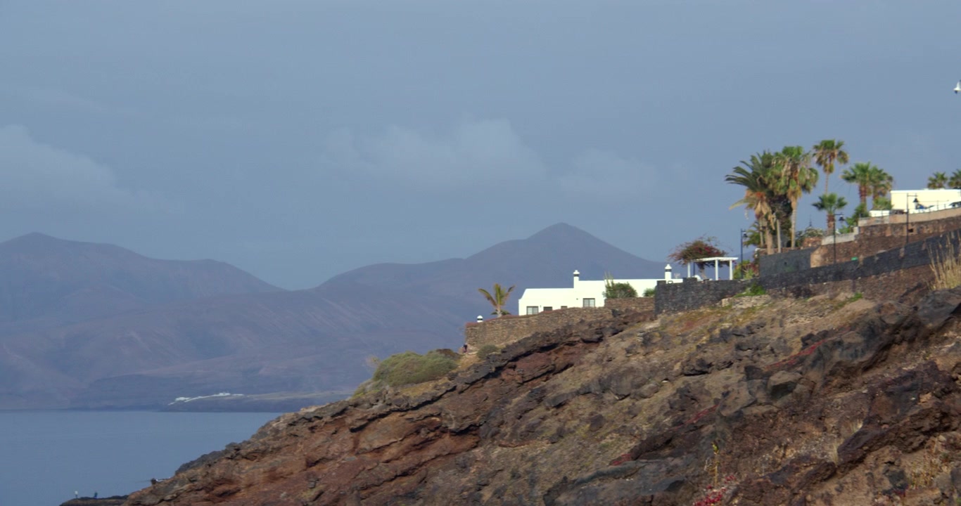 Ripresa panoramica extra-wide di una villa vacanze imbiancata a calce sulla costa di Lanzarote.