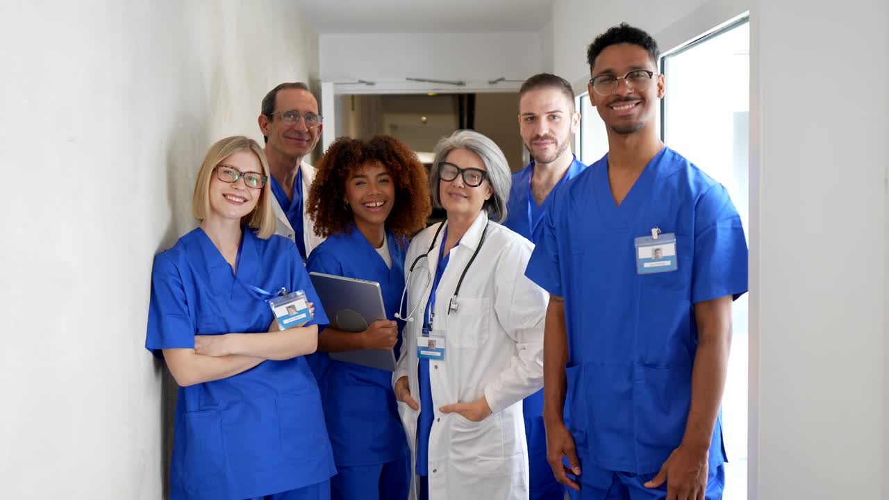 Diverse Group of Medical Professionals Standing and Smiling in Hospital Hallway