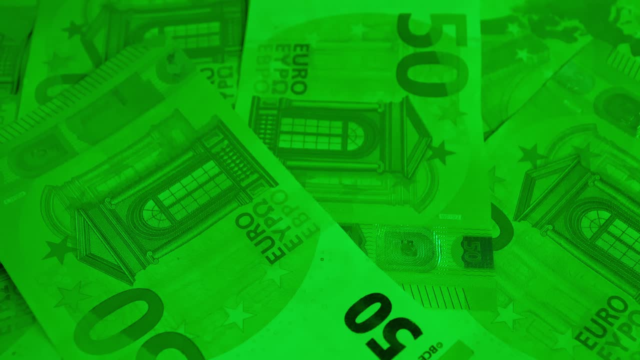 Rotation lente de billets de cinquante euros nets sous une vive lumière verte sur une plateforme