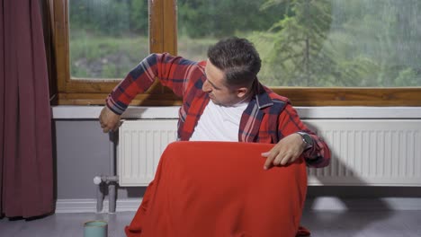 el hombre baja la temperatura del calentador y tiene frío.